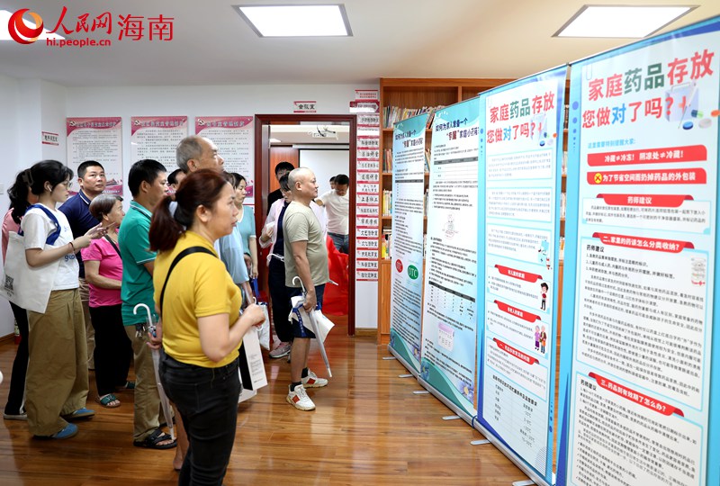 社区居民通过展板增加科学用药的知识。