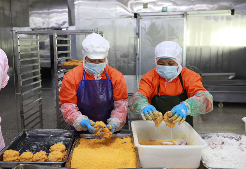 海南力合泰食品有限公司车间内，工作人员各司其职，有条不紊地工作着。