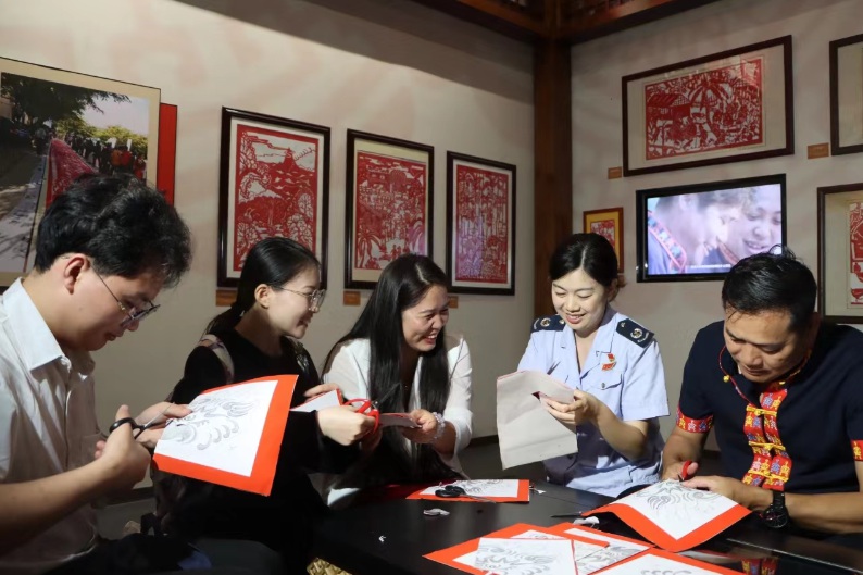 乐东企业代表与税务干部围绕税收宣传月主题进行合作剪纸